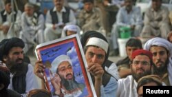 Magoya bayan wata kungiyar Islama suke zanga zanga dauke da hoton marigayi Osama Bin Laden.