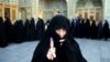 An Iranian woman displays her ink-stained finger after voting in the parliamentary and Experts Assembly elections at a polling station in Qom, Feb. 26, 2016.