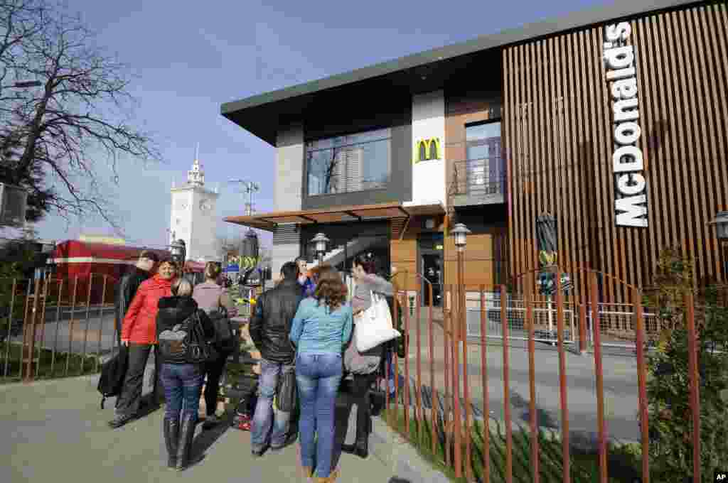 People stand outside a closed McDonalds restaurant.&nbsp;The fast food restaurant chain announced this week that it is shuttering its three outlets in the Crimean peninsula over unspecified operations issues, Simferopol, Crimea, April 4, 2004.