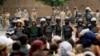 Followers of the Shi'ite Houthi movement stand in front of riot police near the cabinet building in Sanaa Sept. 9, 2014. 