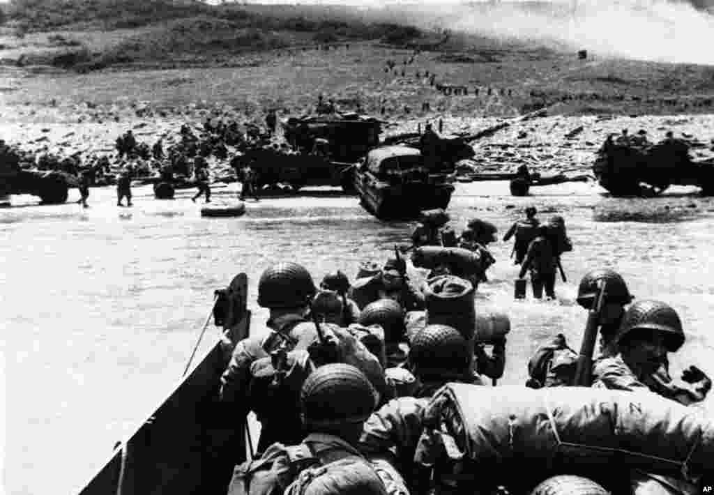 Pasukan Sekutu, dengan truk amfibi mengikuti jejak kaki pasukan selama invasi awal Perancis, di 100 mil garis depan di sepanjang pantai Normandia, 6 Juni 1944.