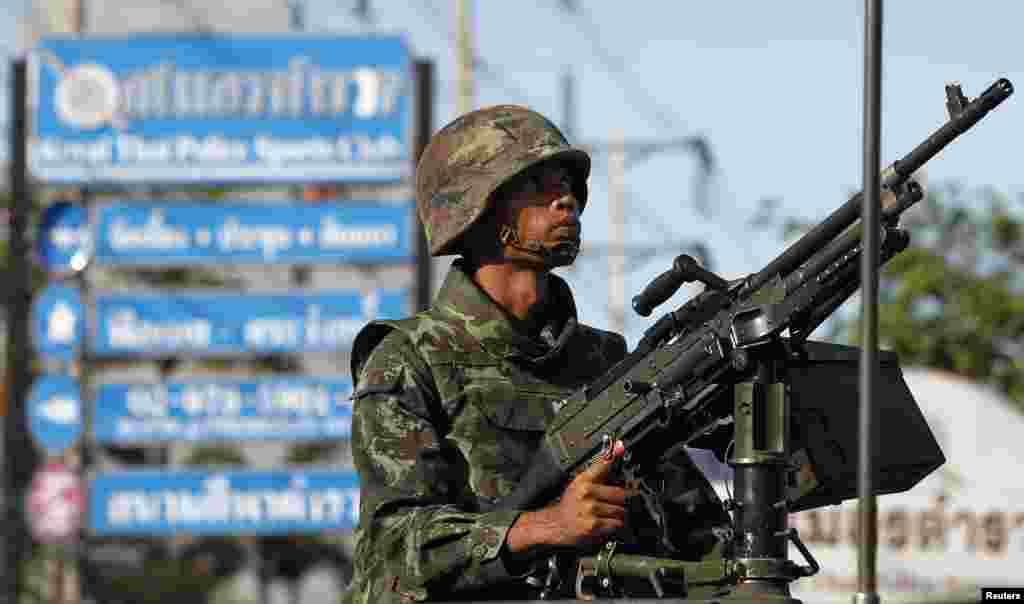 Seorang tentara Thailand bersiaga dengan menggenggam senapan mesin di pusat kota Bangkok, 20 Mei 2014.