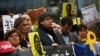 Catalonia's former regional president Carles Puigdemont, center, holds a banner with others during a protest in front of the European Commission headquarters in Brussels, Oct. 15, 2019. 