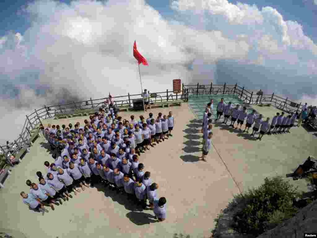 Veterans of the Chinese People's Liberation Army (PLA) stand in formation of a star and the Chinese characters "August 1" on top of a mountain ahead of China's "Army Day" in Luoyang, Henan province, July 31, 2016.