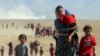 Orang-orang Yazidi, melarikan diri dari kekerasan dari pasukan yang setia kepada ISIS di kota Sinjar, berjalan menuju perbatasan Suriah di pinggiran gunung Sinjar dekat perbatasan Suriah. (Foto: Reuters)