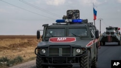 FILE - Russian forces patrol near the city of Qamishli, north Syria, Oct. 24, 2019.