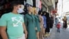 A vendor wearing a face mask stands in front of his school uniform shop, ahead of the first day of the new school year, amid fears of rising number of the COVID-19 cases in Amman, Jordan, Aug. 31, 2020.