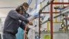 In this Oct. 10, 2013, file photo, employees at Sheffield Platers Inc. work on the factory floor in San Diego.