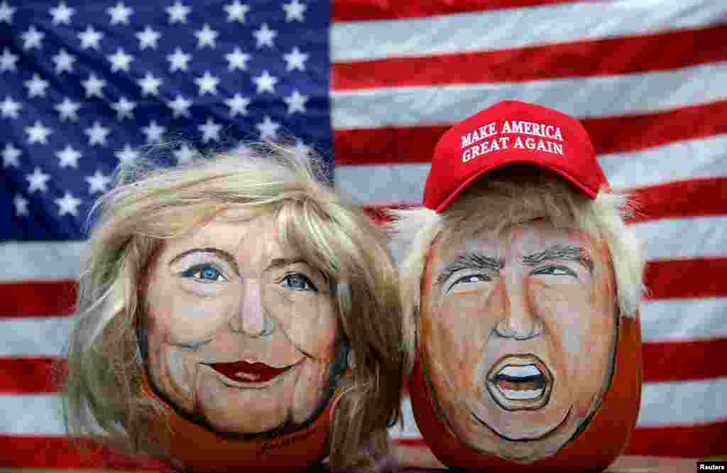 The images of U.S. Democratic presidential candidate Hillary Clinton (L) and Republican Presidential candidate Donald Trump are seen painted on pumpkins created by artist John Kettman in LaSalle, Illinois, June 8, 2016.