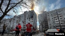 Парамедики та рятувальники біля зруйнованого внаслідок російського обстрілу житлового будинку, Запоріжжя. Україна. 22 березня , 2023. REUTERS/Sergiy Chalyi