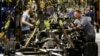 File - A worker prepares a chassis to receive an engine at Ford's Kansas City Assembly Plant in Claycomo, Missouri, March 2015.