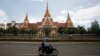  អ្នក​បើក​ម៉ូតូ​ម្នាក់​ជិត​កាត់​​អគារ​វិមាន​រដ្ឋសភា​ជាតិ​នៅ​រាជធានី​ភ្នំពេញ​កាល​ពី​ថ្ងៃ​ទី​២៦ ខែ​សីហា ឆ្នាំ​២០១៤។