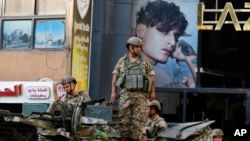 Lebanese army soldiers on their armored vehicle stand guard in Beirut, Oct. 15, 2021, at the site where deadly clashes erupted the previous day.