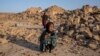 FILE- An Afghan girl cries in front of her house that was destroyed by the earthquake in western Afghanistan, on Oct. 11, 2023. Almost 100,000 children need support three months after earthquakes devastated the Herat region, the U.N. children’s agency said Jan. 15, 2024.