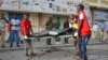 Medical workers remove the body of a civilian who was killed in a car bomb explosion near the parliament building in the capital Mogadishu, Somalia, March 25, 2018. 