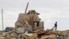 Shi'ite fighters known as Houthis stand on the rubble of a house destroyed by a Saudi airstrike in Sana'a, Yemen, Wednesday, Aug. 26, 2015.