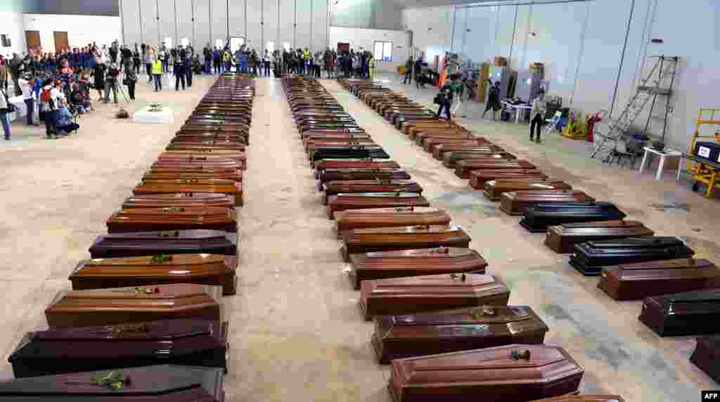 Peti mati korban terlihat di hanggar bandara Lampedusa, 5 Oktober 2013, setelah sebuah kapal berisi imigran tenggelam menewaskan lebih dari 100 orang. Layanan darurat Italia berharap untuk melanjutkan pencarian mayat meskipun kondisi laut yang tidak bersahabat setelah kecelakaan tersebut, di mana 111 pencari suaka dikonfirmasi meninggal dan sekitar 200 orang masih hilang.