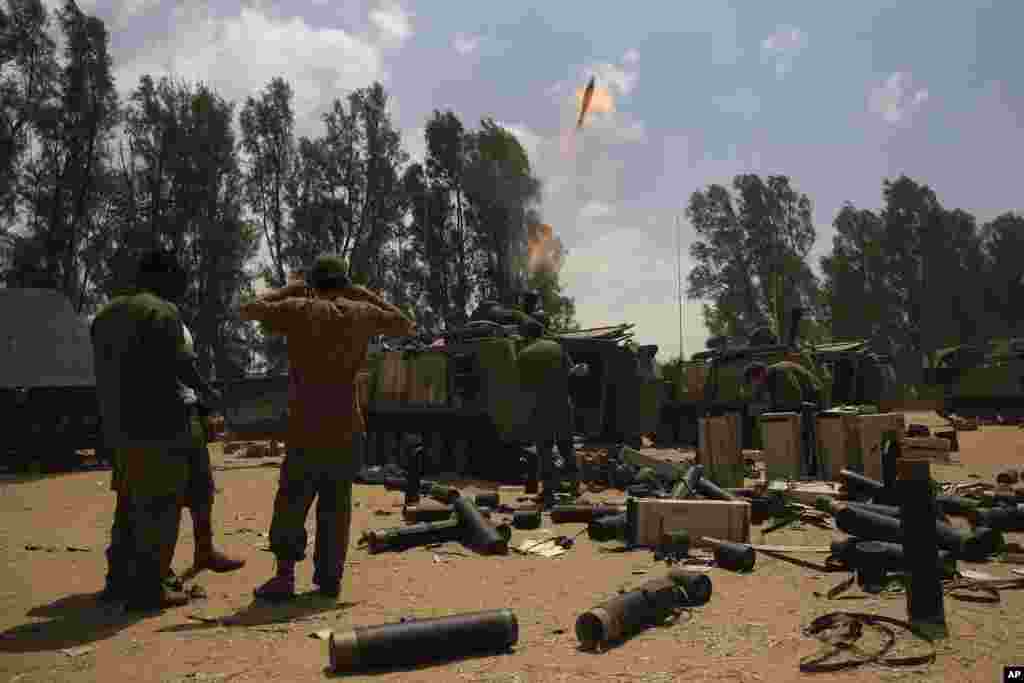 Israeli soldiers fire a mortar shell towards the Gaza Strip, near the Israel - Gaza border, Aug. 4, 2014. 