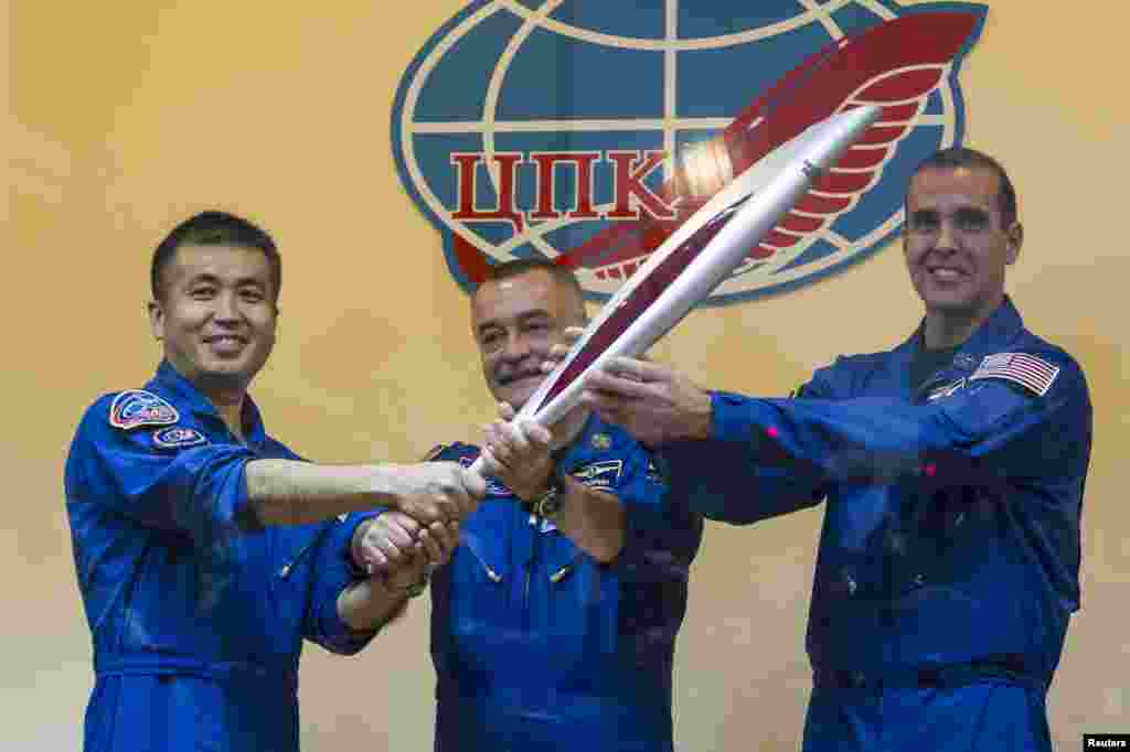 Astronot Jepang Koichi Wakata, kosmonot Rusia Mikhail Tyurin dan astronot AS Rick Mastracchio, memegang obor Olimpiade dalam konferensi pers sebelum peluncuran (6/11). 