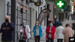 People wearing face masks to protect against coronavirus walk during their allocated time slots for age groups and activities in Madrid, Spain, May 13, 2020.