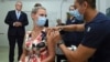 Australian Prime Minister Scott Morrison, left, watches as Sarah Fletcher receiving a vaccine at the Sydney local health district vaccination hub in Sydney, Feb. 19, 2021.