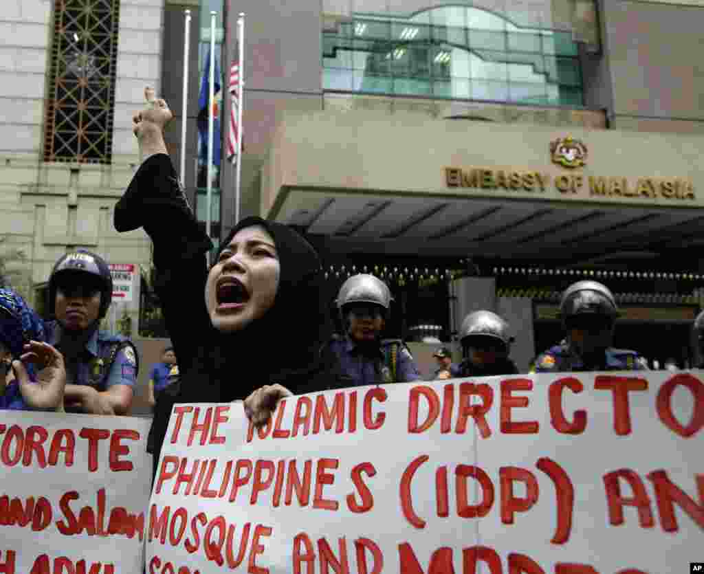 Philippine Muslim protesters shout slogans against the military assault launched by Malaysian forces in Borneo during a rally at the Malaysian Embassy east of Manila, Philippines, March 5, 2013.