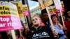 People hold anti-racism placards as they take part in a demonstration outside the headquarters of the Reform U.K. political party in London on Aug. 10, 2024.