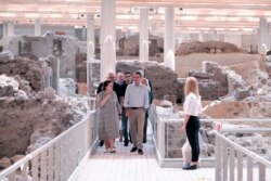In this handout photo provided by the Prime Minister's Office, Greek Culture Minister Lina Mendoni, left, walks next to Greek Prime Minister Kyriakos Mitsotakis during their visit to the Greek island of Santorini.