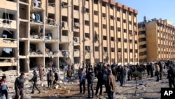 Warga Suriah berkumpul di dekat lokasi ledakan di Universitas Aleppo, Suriah, 15 Januari 2013. (AP Photo/SANA). Jumlah korban dalam ledakan ini dilaporkan mencapai 83 orang tewas dan lebih dari 150 orang lainnya luka-luka.
