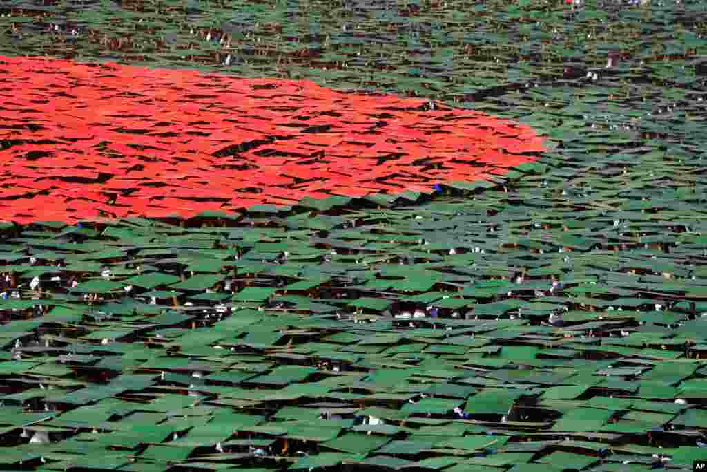 Warga Bangladesh menggunakan kertas warna-warni untuk membentuk bendera nasional dalam perayaan HUT Kemerdekaan Bangladesh di ibukota Dhaka.
