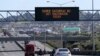 FILE - A sign on an Auckland motorway urges people to get vaccinated at a COVID-19 vaccination clinic during a single-day vaccination drive, in Auckland, New Zealand, Oct. 16, 2021. 
