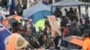 FILE - Protesters stand in the rain in Parliament grounds in Wellington on Feb. 12, 2022, on the fifth day of demonstrations against Covid restrictions. 