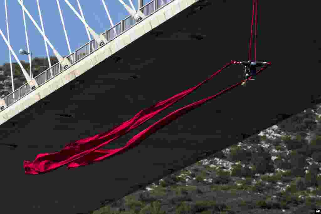 Seorang penari "ekstrem" Katerina Soldatou melakukan tarian di atas ketinggian 34 meter di bawah jembatan Chalkida, utara Athena, Yunani.