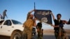 Iraqi Shiite militia fighters hold the Islamic State flag as they celebrate after breaking the siege of Amerli by Islamic State militants, Sept. 1, 2014. 