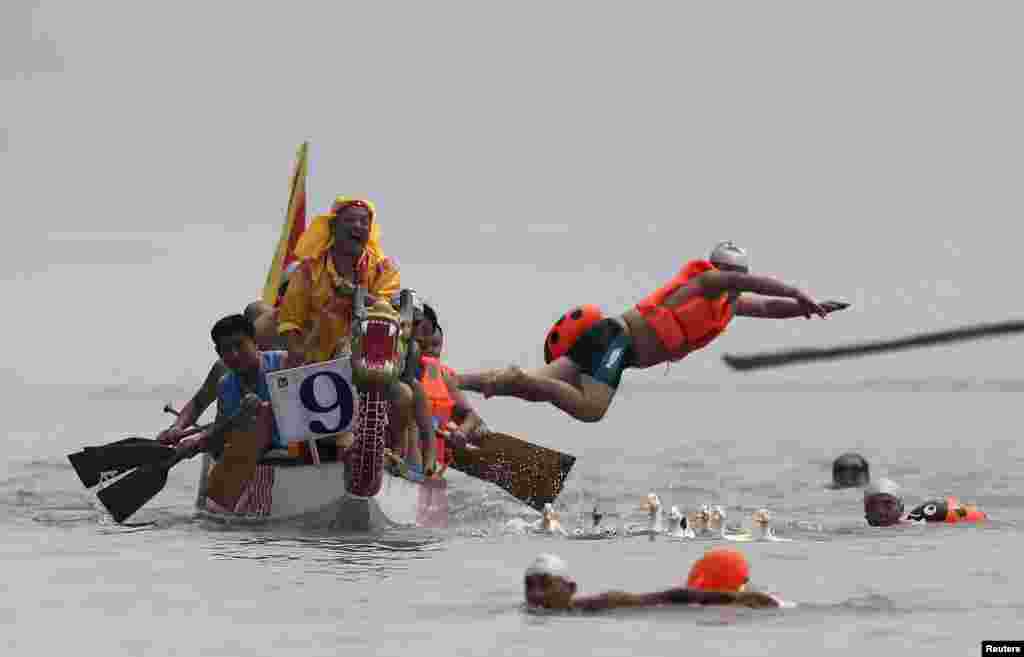 Peserta melompat ke sungai Yangtze&nbsp;untuk menangkat itik dan angsa sebagai bagian perayaan Festival Perahu Naga di kota Yibin, Sichuan, China.