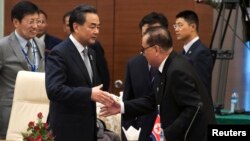 왕이 중국 외교부장(왼쪽)과 리수용 북한 외무상이 지난 8월 미얀마 수도 네피도에서 열린 아세안지역안보포럼(ARF)에서 만나 악수하고 있다. (자료사진)