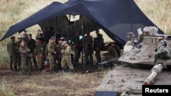 Des soldats israéliens près d'un char sur les hauteurs du Golan occupé par Israël, le 9 mai 2018.

