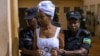 Diane Shima Rwigara escortée par des policières dans une salle d'audience à Kigali, au Rwanda, le 11 octobre 2017.
