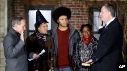 Bill de Blasio (kanan) disumpah sebagai walikota New York City oleh Jaksa Agung Eric Schneiderman (kiri), disaksikan keluarganya. (AP/Seth Wenig)