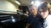 Ray Whelan (L), of Switzerland-based Match Services, arrives at a police station after being arrested in connection with the illegal resale of tickets at the World Cup, in Rio de Janeiro, July 7, 2014. 
