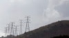FILE - Electricity pylons snake across a hill in a Johannesburg suburb.