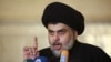 FILE - Iraqi Shi'ite radical leader Muqtada al-Sadr delivers a sermon to worshippers during Friday prayers at the Kufa mosque near Najaf, Dec. 11, 2015.