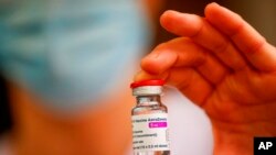 FILE - A member of the medical staff holds a vial of the AstraZeneca-Oxford COVID-19 vaccine at the South Ile-de-France Hospital Group in Melun, in the outskirts of Paris, Feb. 8, 2021. 
