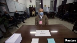 Un électeur portant un masque facial pour se protéger contre la maladie à coronavirus (COVID-19), dans un bureau où les Algériens votent lors du référendum constitutionnel à Alger, en Algérie, le 1er novembre 2020.
