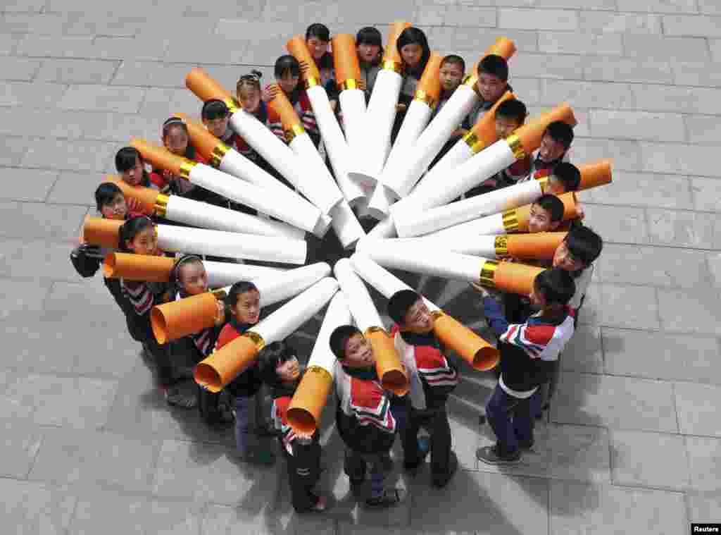 Para siswa sebuah sekolah dasar di Handan, Provinsi Hebei, Cina berpose dengan &quot;model rokok besar&quot; dalam kampanye menjelang Hari Tanpa Tembakau Sedunia, 29 Mei 2013.