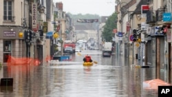 Residents use a canoe to evacuate in downtown Nemours, 50 miles south of Paris, June 2, 2016. 