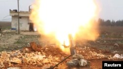 Archives - Des combattants de l'armée syrienne tirent un obus vers les combattants de l'Etat islamique dans le nord d'Alep, en Syrie.