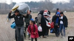 Des migrants marchent près de Pazarkule à la frontière greco-turque le 5 mars 2020.