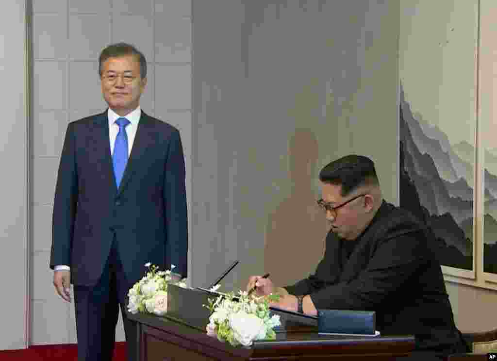 Le dirigeant nord-coréen Kim Jong Un signe un livre, à l'intérieur de la Maison de la Paix, dans le village frontalier de Panmunjom, à Demilitariz, le 27 avril 2018.