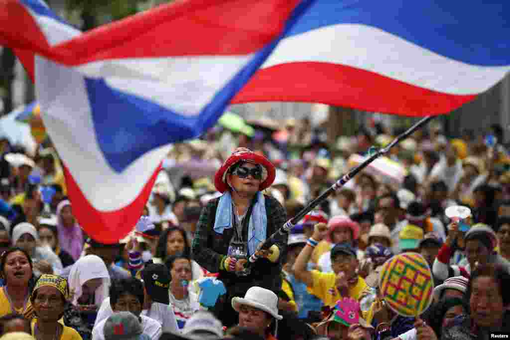 Seorang pengunjuk rasa anti-pemerintah melambaikan bendera dalam sebuah unjuk rasa di luar kompleks parlemen negara itu di&nbsp; mana anggota Senat berkumpul untuk sebuah pertemuan, di Bangkok, Thailand. &nbsp;